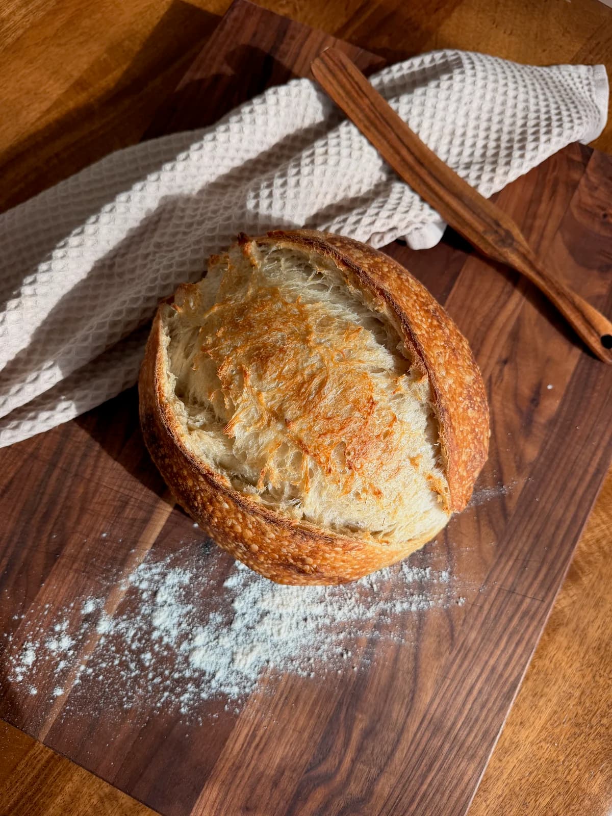 A freshly baked loaf of The Hazel country sourdough resting on linen